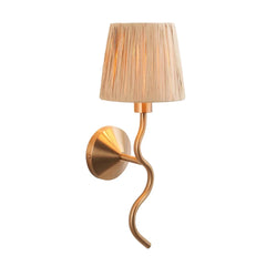 Gold wall sconce with a pleated lampshade on a white background