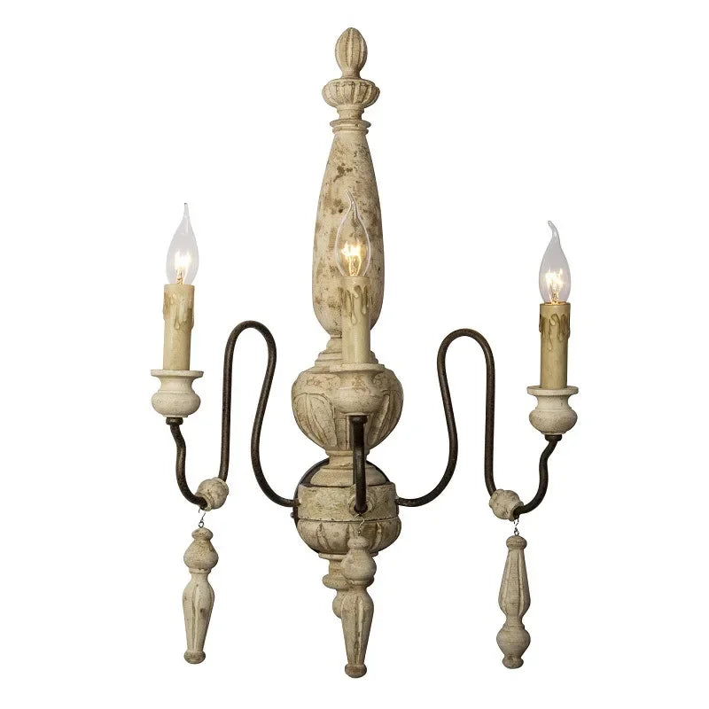 Decorative wall sconce with three candle-style lights on a white background