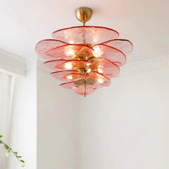 Interior scene featuring a pink glass leaf chandelier illuminating a living space.