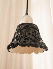 Decorative pendant light with intricate design on a plain background