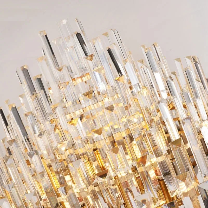 Detailed shot of the many crystal prisms hanging from the gold frame of a chandelier.