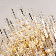 Detailed shot of the many crystal prisms hanging from the gold frame of a chandelier.