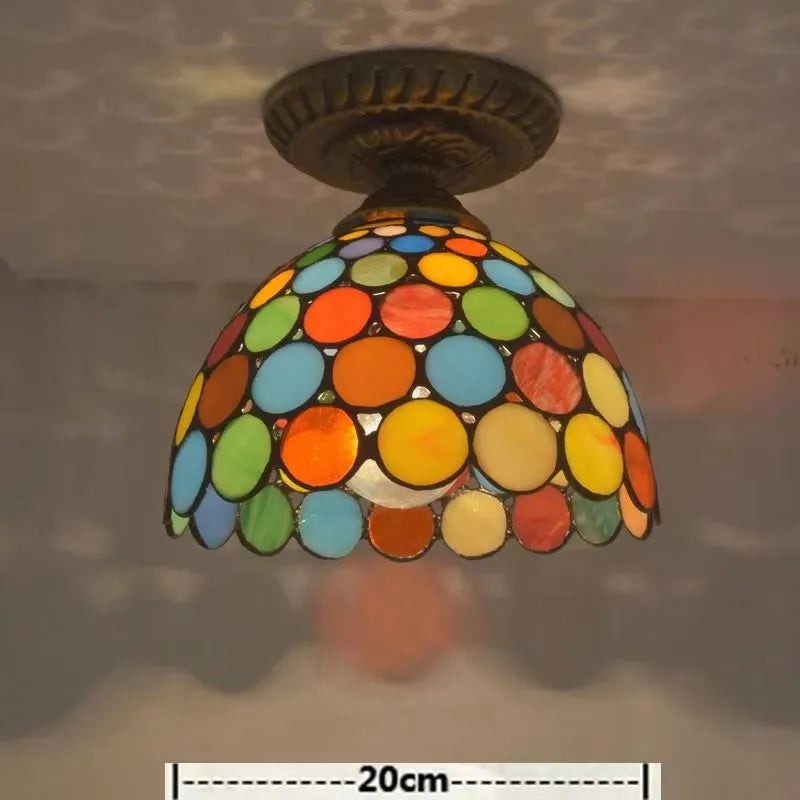 A close-up of a Tiffany-style ceiling light fixture with a dome-shaped shade made of colorful circular glass pieces, with a dimension indicator of 20cm.