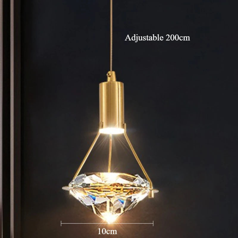 Gold pendant light with crystal design on a dark background