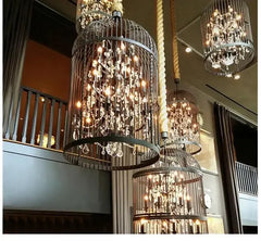 Decorative chandeliers hanging in a room with a staircase.