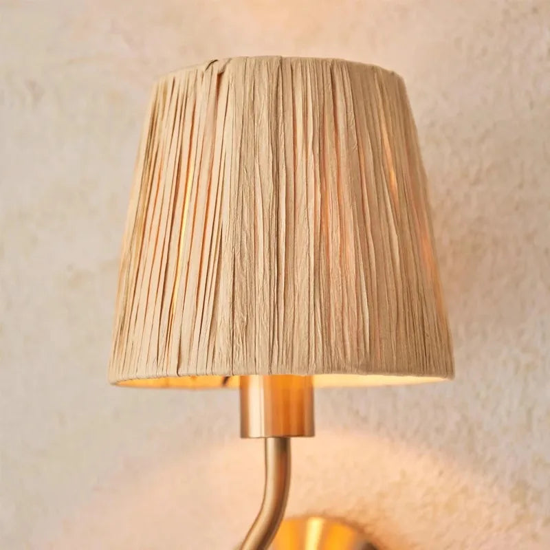 Wall-mounted lamp with pleated beige shade against a neutral wall