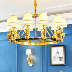 Gold chandelier with lion head designs against a blue wall.