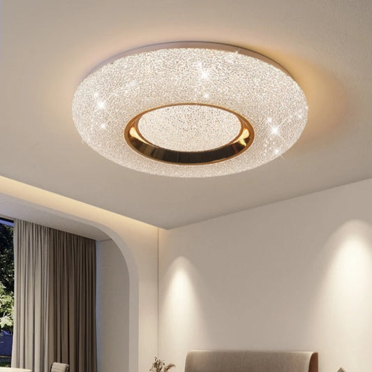 Circular flush mount ceiling light with a textured white surround and a central gold ring, studded with small sparkling lights.