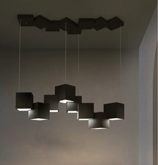 Modern black pendant light fixture hanging in a room with a neutral background