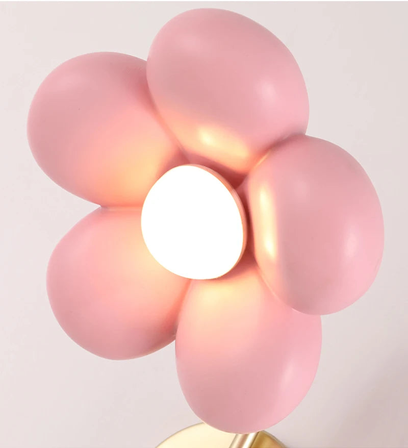 Decorative light fixture with pink balloon-like design on a plain background