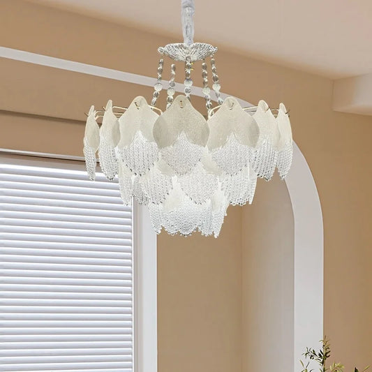White glass leaf tiered chandelier hanging in a room with natural light