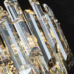 Close-up of a crystal chandelier with clear and gold elements against a dark background