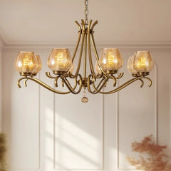 Close-up view of a gold chandelier arm with a seeded glass shade and an illuminated LED bulb.