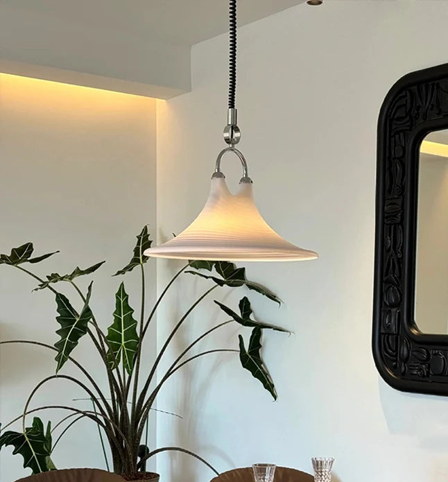 Dining area with a wooden table, chairs, and a large mirror on the wall.