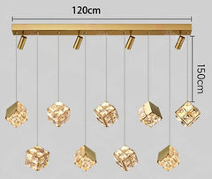Gold pendant light fixture with crystal-like shades and measurement labels on a gray background