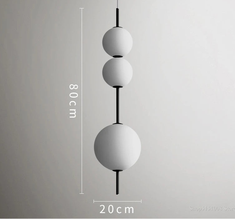 Modern pendant light with three spherical shades on a gray background