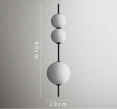 Modern pendant light with three spherical shades on a gray background