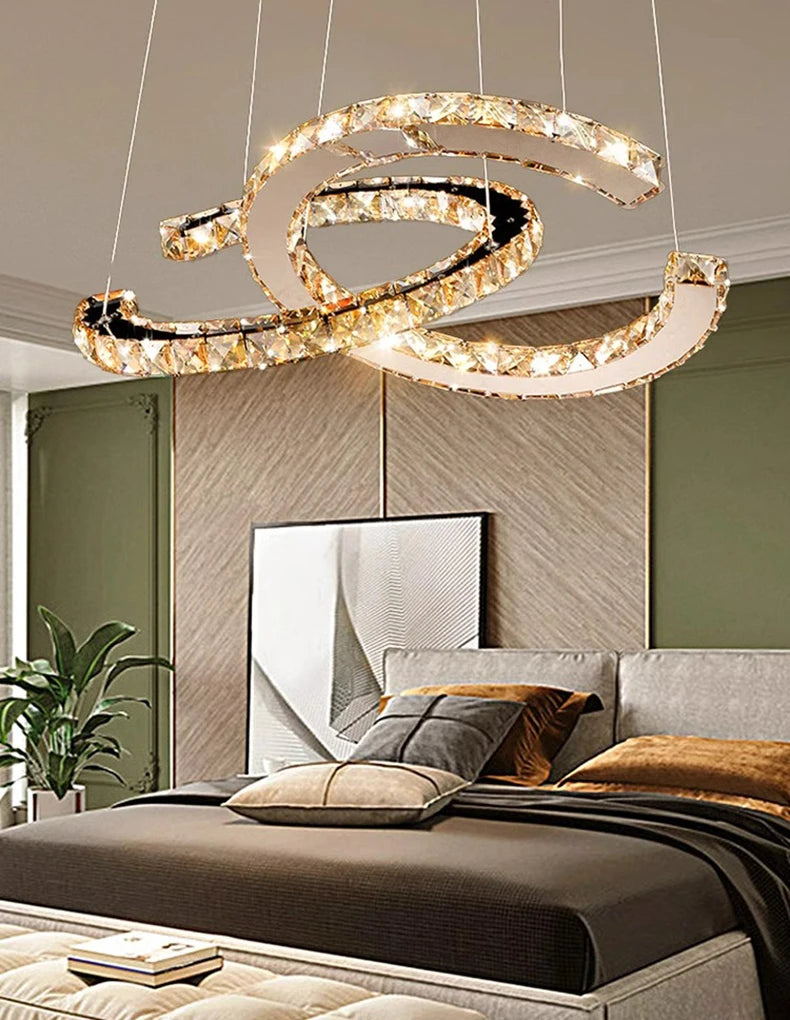 Modern chandelier hanging above a bed in a bedroom setting