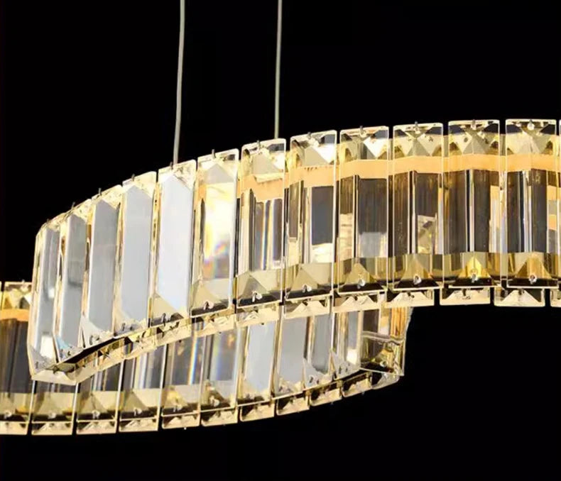 Gold chandelier with clear crystals against a black background