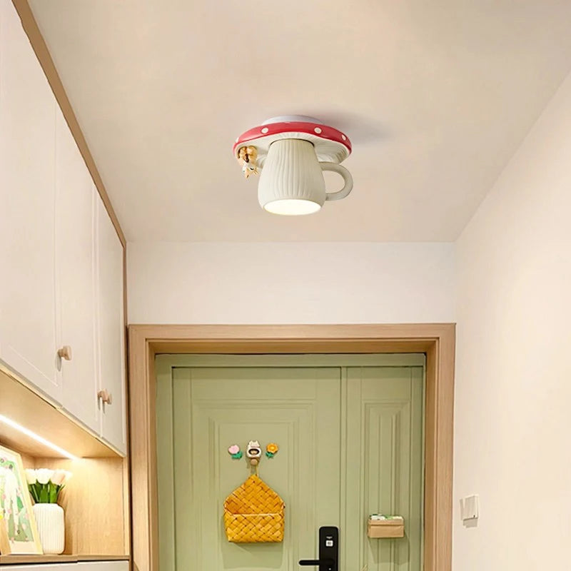 A red and white mushroom-shaped ceiling light with a squirrel accent mounted on a white ceiling above a light green door.