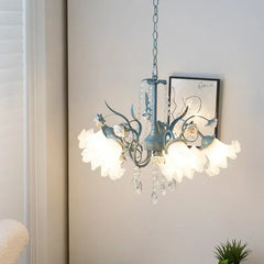 Side view of a blue floral ceramic chandelier with crystal accents, mounted on a white wall with a framed artwork.