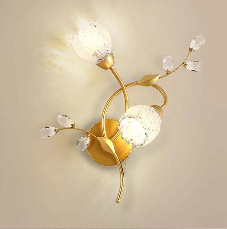 Decorative wall lamp with gold finish and crystal-like elements on a beige background