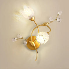 Decorative wall lamp with gold finish and crystal-like elements on a beige background