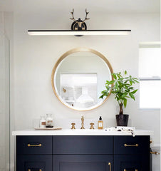 Bathroom vanity with round mirror, decorative items, and a plant.