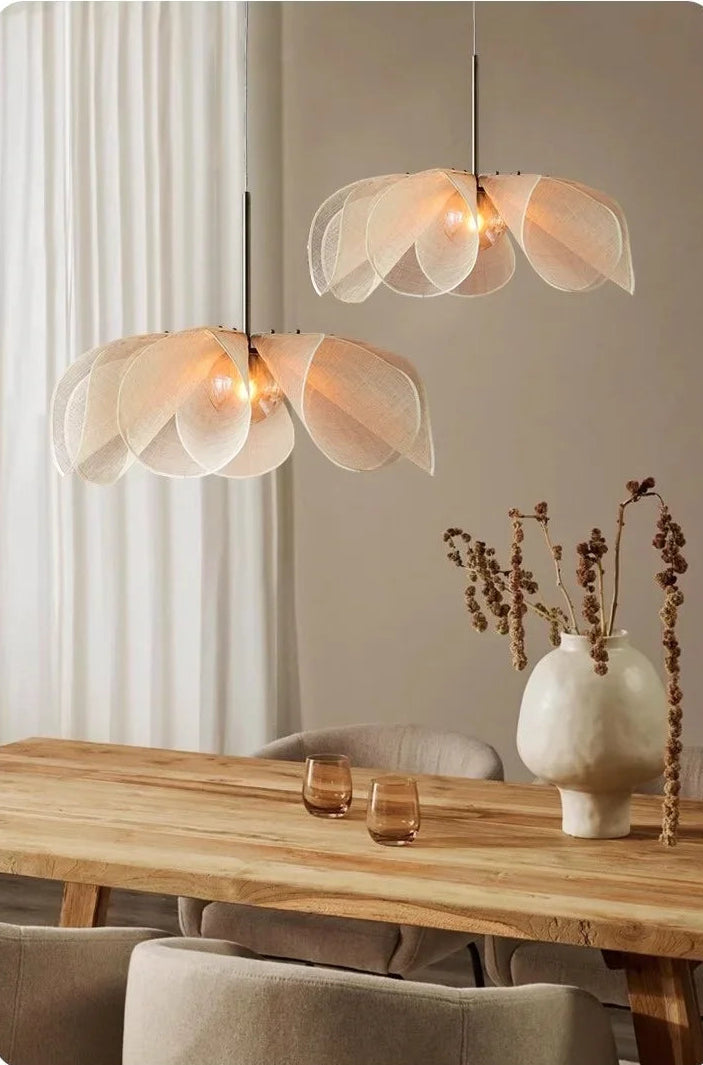 Modern pendant lights hanging above a wooden table with decorative items.