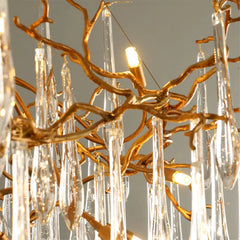 Gold branch-like chandelier with clear crystal elements on a gray background
