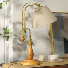 Vintage-style table lamp with wooden base and beige shade on a surface.