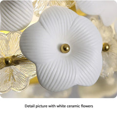 Close-up of white ceramic flowers with gold accents on a light background