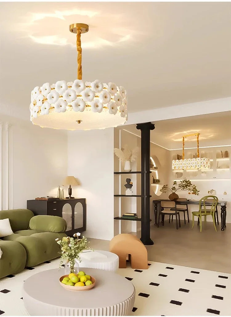 Modern living room with a decorative chandelier, green sofa, and coffee table.