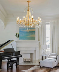 Living room with a grand piano, chandelier, and fireplace.
