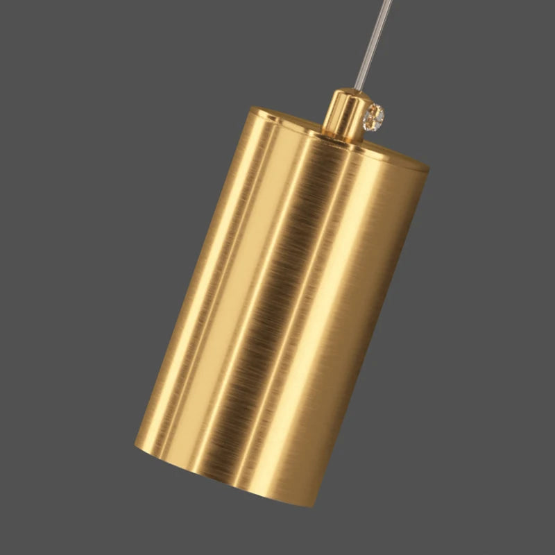 Gold cylindrical pendant light on a dark gray background