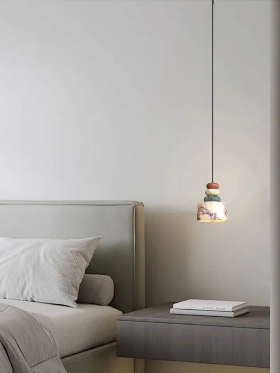 Modern bedroom with a bed and a side table featuring a pendant light.