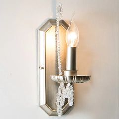 Decorative wall sconce with crystal accents on a light background