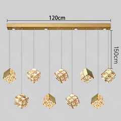 Gold pendant light fixture with crystal-like shades and measurements on a gray background