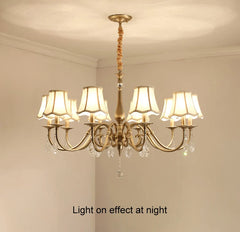 Gold chandelier with white lampshades in a room setting