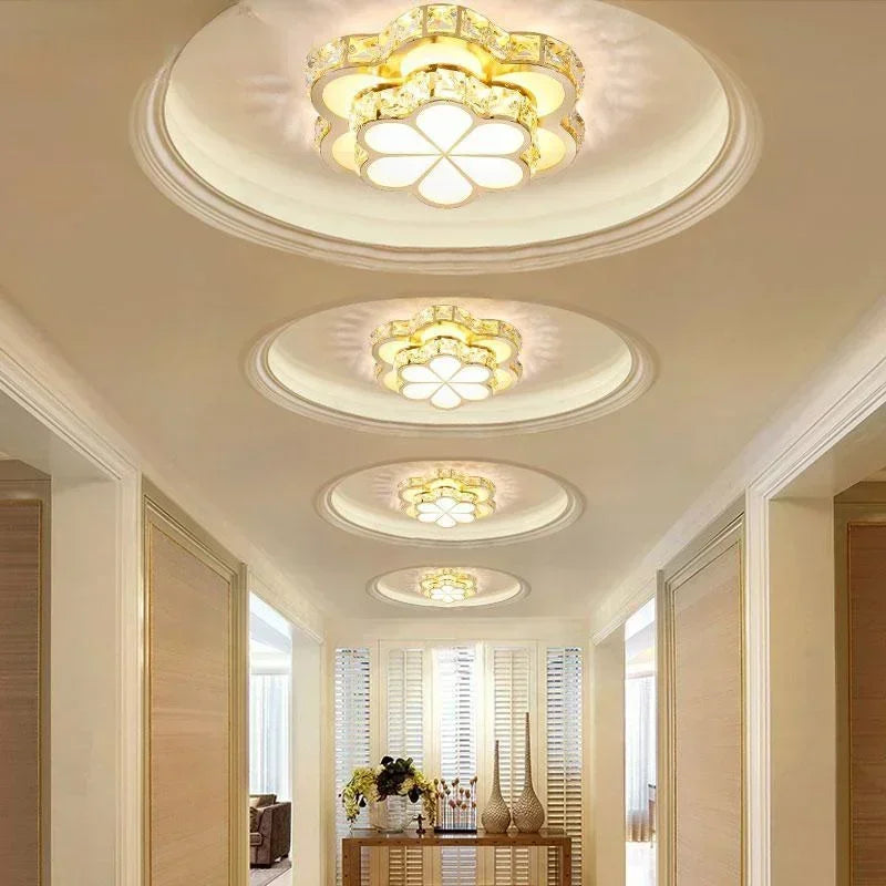 A hallway illuminated by multiple gold and crystal flower flush mount ceiling lights.