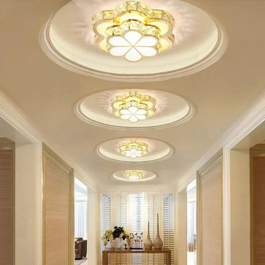 A hallway illuminated by multiple gold and crystal flower flush mount ceiling lights.