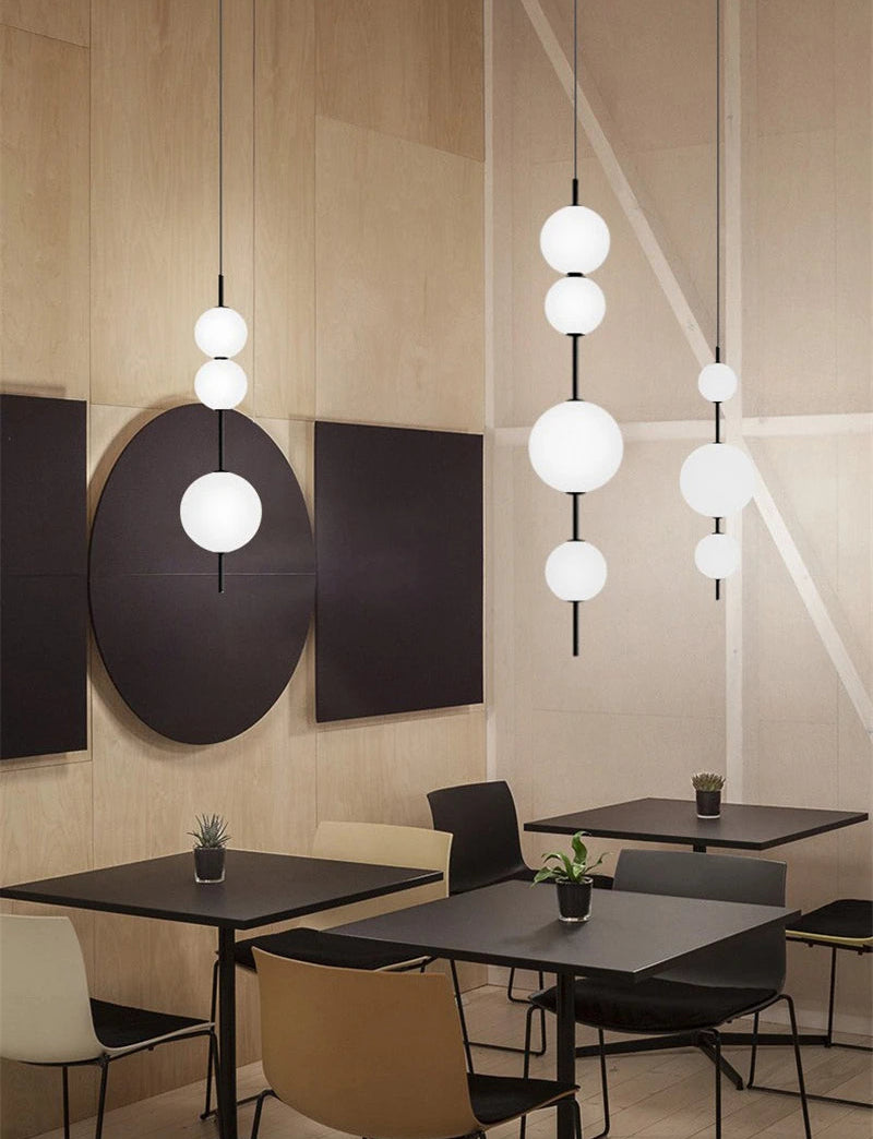 Modern restaurant interior with pendant lights, tables, and chairs.