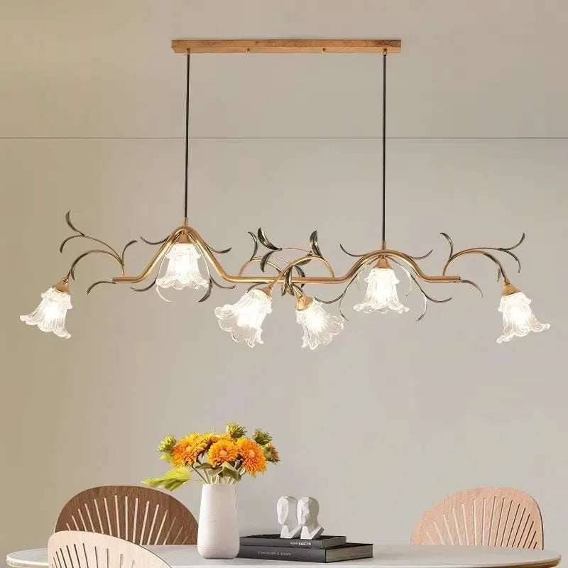 Close-up view of the gold floral branch pendant light, highlighting the intricate details of the metalwork and glass shades.