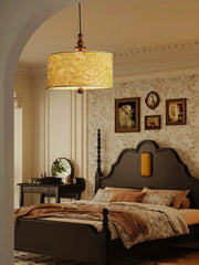 Green floral fabric drum pendant light with wood accents in a bedroom