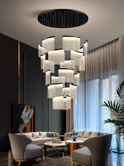 Modern living room with a stylish chandelier, gray sofa, and decorative elements.
