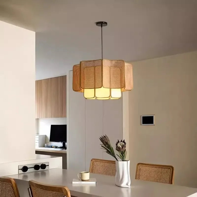 A natural-toned rattan woven tiered pendant light illuminating a dining area with a modern Bohemian aesthetic.