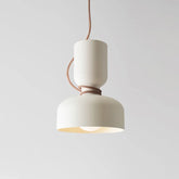 Close-up of a matte black dome pendant light with a contrasting brown cord against a white background.