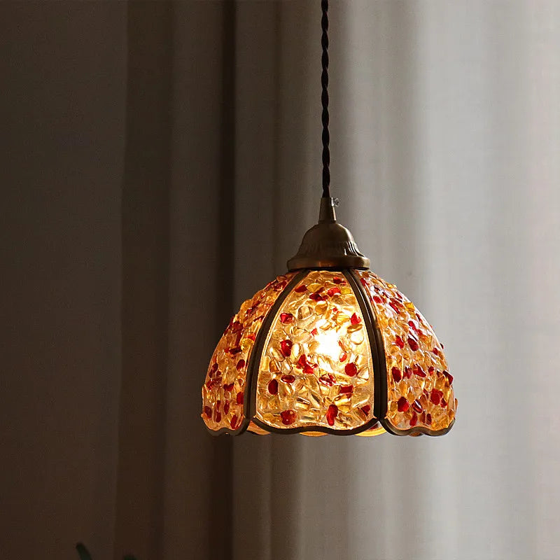 Decorative pendant light with a mosaic glass shade against a neutral background
