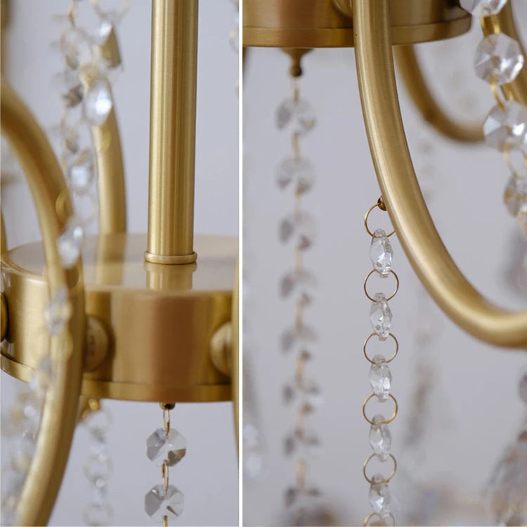 Close-up of a gold chandelier with crystal accents against a neutral background