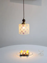 Small pendant light with a checkered glass shade on a white surface.